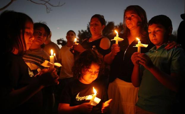 Varias personas portan velas en el velatorio de Parkland. 