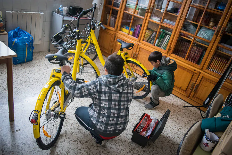 Dos chicos arreglan una bici en el colegio Luisa de Marillac. 