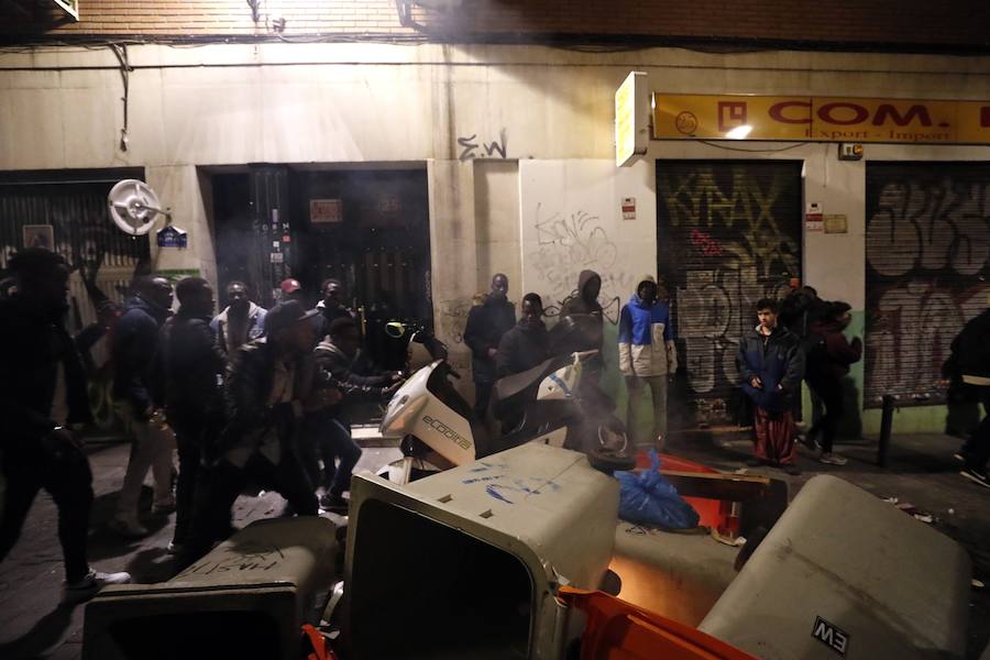 Un grupo de más de medio centenar de personas han quemado contenedores y causado desperfectos en el mobiliario urbano en el madrileño barrio de Lavapiés tras la muerte este jueves de un mantero de 35 años y origen subsahariano a causa de una parada cardiorrespiratoria.