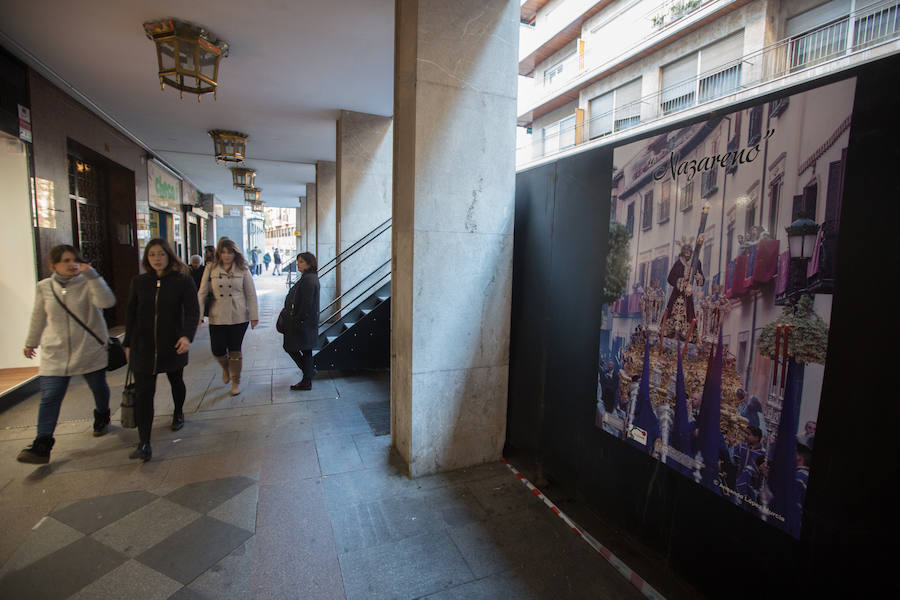 El Ayuntamiento inaugura una muestra de carteles con las fotos de Semana Santa de 2017 para embellecer la céntrica calle 'tapando' la parte trasera de las gradas de la carrera oficial.