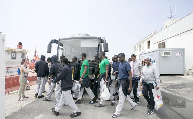 Un grupo de inmigrantes sale del centro de acogida del puerto de Motril. 