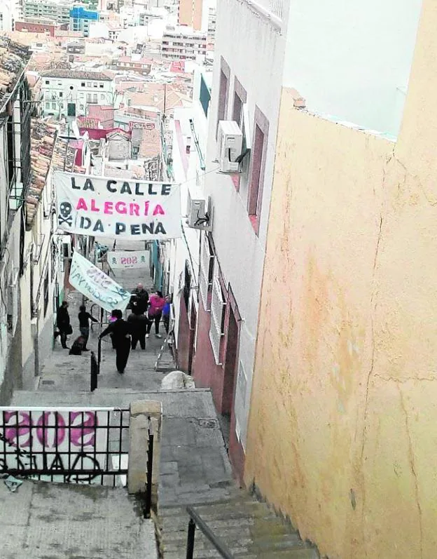 Vecinos del barrio de San Juan colocan pancartas con una llamada de SOS por el estado del casco antiguo, tras el derrumbe en la calle Alegría 