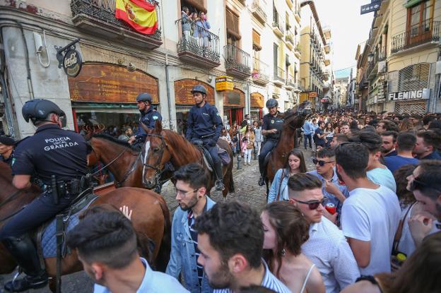 La Policía Local entra a caballo por San Jerónimo para dispersar a los jóvenes congregados junto a la plaza de la Universidad.