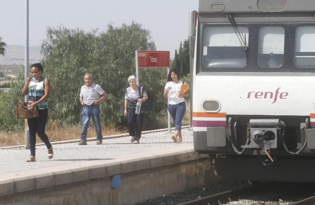 Viajeros del tren de cercanías de la línea Murcia-Águilas descienden en la estación del municipio de Totana. 