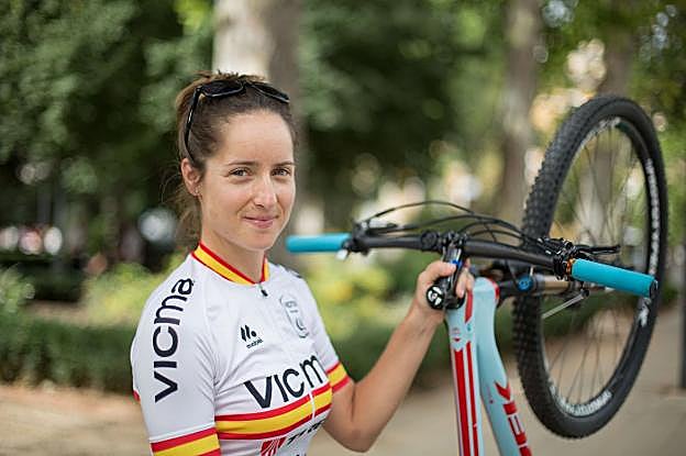 Rocío Martín posa sonriente mientras sujeta su bicicleta.