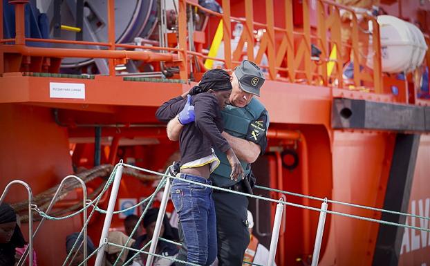 Un agente de la Guardia Civil ayuda a una de las rescatadas 