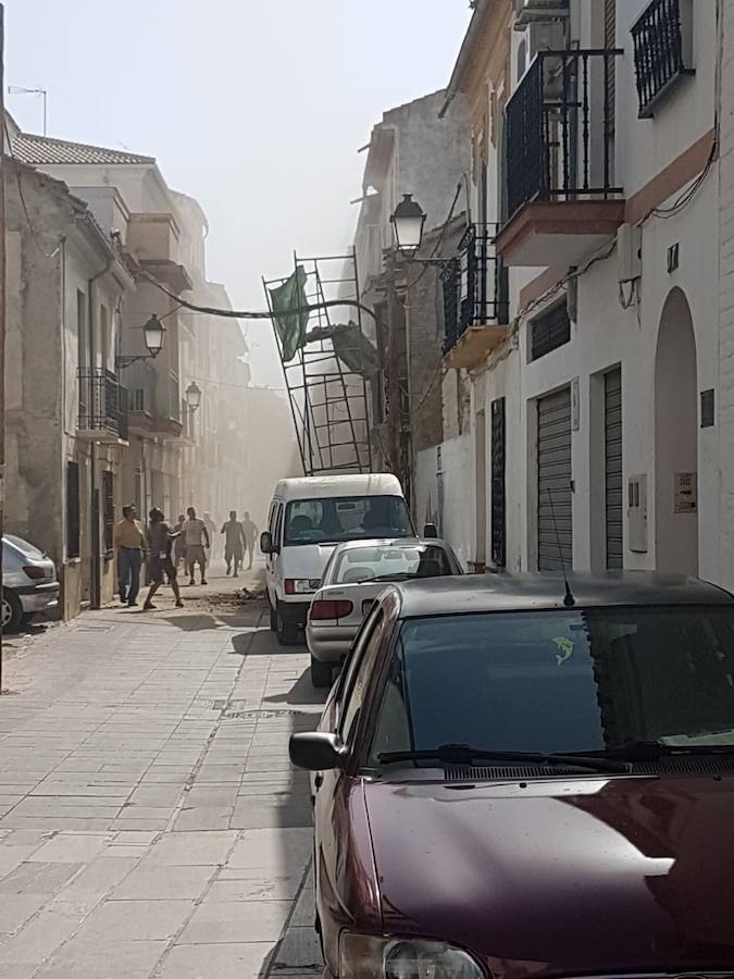 Unos trabajadores tienen que saltar del andamio en el que estaban retirando las tejas de un edificio al empezar a caerse la fachada