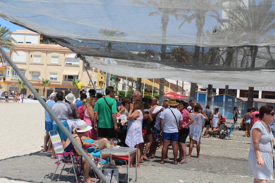 Los vecinos y turistas disfrutan de un dçía de fiesta a pie de playa. Feria de día con tapas, y fiesta de noche con con el rock and roll del grupo Kasia.