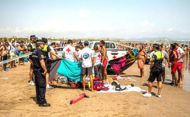 Miembros de la Cruz Roja junto al cadáver en la playa de la Malvarrosa.