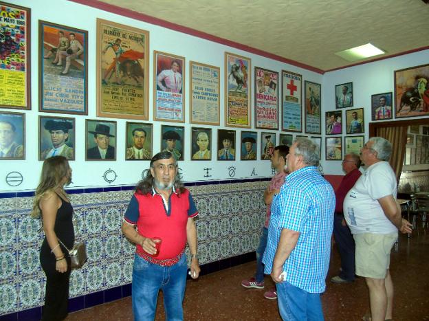 José Vargas, en primer término, con varios visitantes observando a su lado los carteles