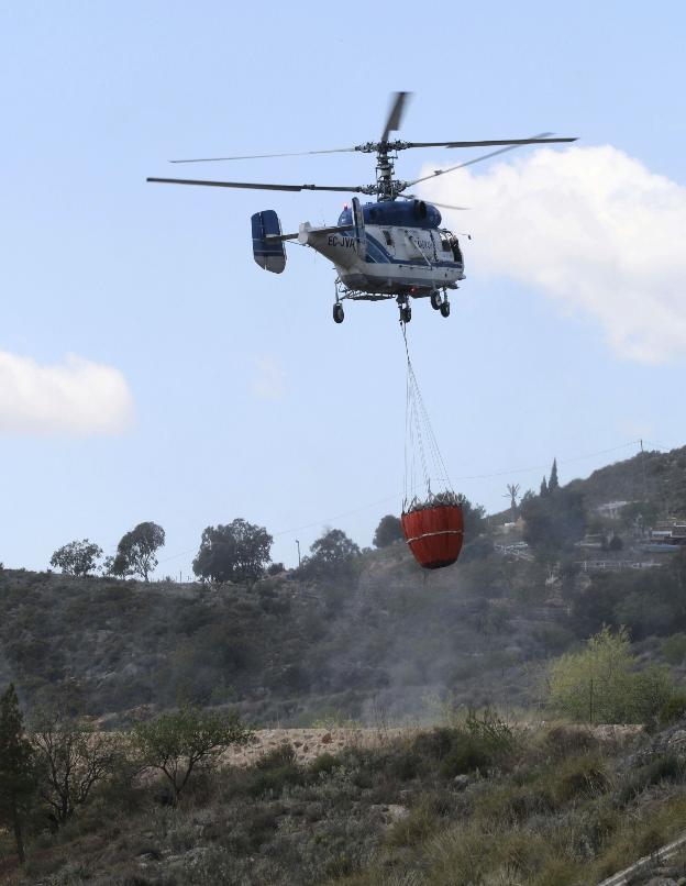 Un helicóptero de Infoca transporta agua para sofocar un incendio.
