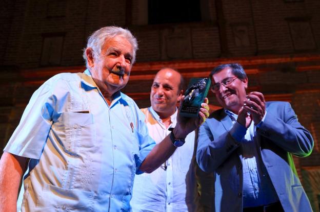 Mujica sonríe al recibir el Laurel de Plata, con el alcalde de La Zubia y el presidente de la Diputación.