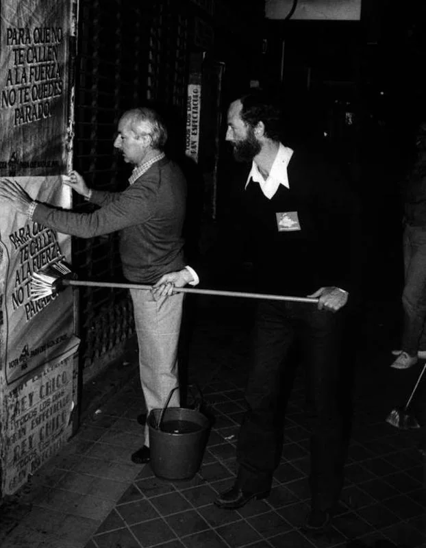 Rafael Fernández Piñar y Afán de la Rivera, dcha, ayuda por Jaime Ballesteros, procede a pegar un cartel del PCE para las elecciones generales. 