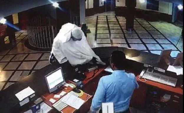 Fotograma del vídeo en el que el atracador salta por encima del mostrador.