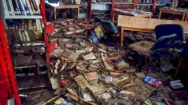 Así dejó la riada las estanterías de la biblioteca pública de Cebolla. El lodo ha echado a perder diez mil libros. 
