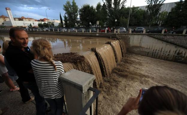 Imagen. Los ciudadanos se paran ante la impactante estampa del río Genil a su paso por Granada capital.