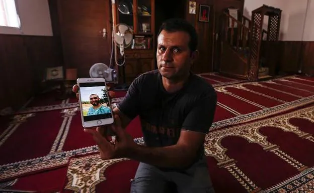 El cuñado del imán de La Rábita expulsado a Marruecos, con una foto de él en la mano.