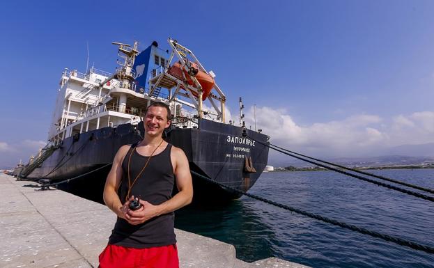 Sergei posa en el puerto de Motril con el barco 'en quiebra' detrás. 