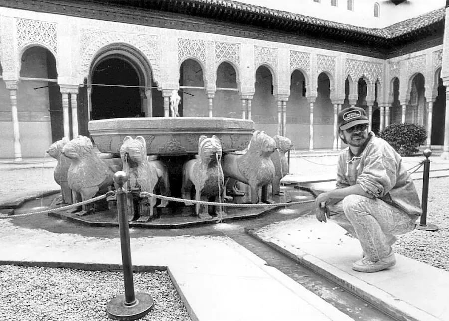 Un joven Steven Spielberg, con sudadera y gorra, posa junto a la fuente ya protegida del Patio de los Leones, en el año 1988. 