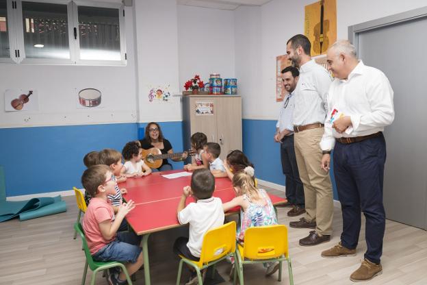 Alcalde, concejal y gerente con un grupo de niños en una de las aulas.