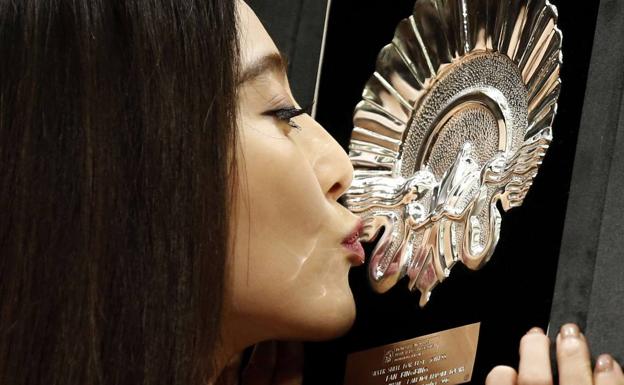 Fan Bingbing besa la Concha de Plata que ganó en el Festival de San Sebastián de 2016 por 'Yo no soy Madame Bovary'.