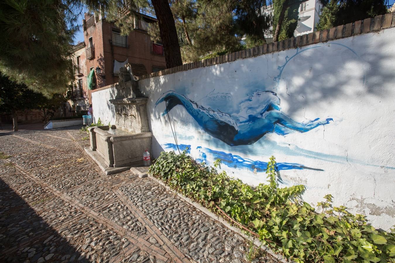 Una sirena azul ha aparecido en el muro del Pilar de la Cuesta de la Escoriaza y ha levantado la polémica entre algunos vecinos por «vulnerar el patrimonio histórico» e «infringir la normativa local que regula los grafitis en las zonas protegidas de la ciudad» como lo es el Realejo. Quien dio ayer la voz de alarma a través de Twitter fue la activista Mayte Martínez, quien acusó al artista granadino el Niño de las Pinturas de cometer «un acto vandálico» a pesar de pintar «verdaderas obras de arte».