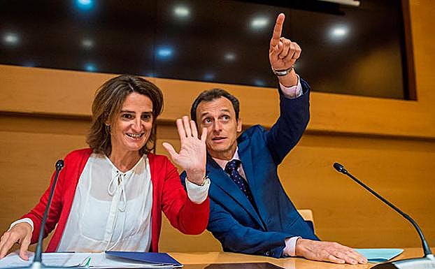 La ministra para la Transición Ecológica, Teresa Ribera, y el ministro de Ciencia, Innovación y Universidades, Pedro Duque, saludan a Telma Cruz del ITC por videoconferencia, durante la rueda de prensa donde valoran las conclusiones del informe especial del Grupo de Expertos en Cambio Climático de Naciones Unidas. 
