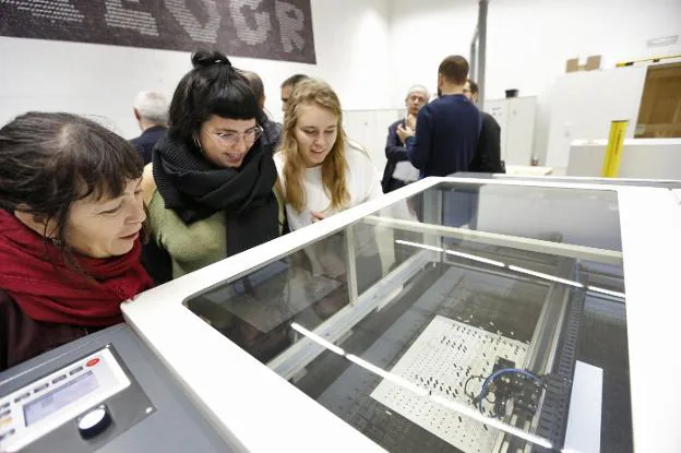 Tres mujeres observan una de las máquinas que se pueden ver en MakerSpace.