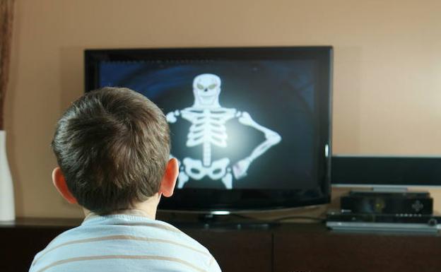 Un niño ve dibujos animados en la televisión.