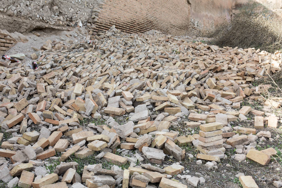 Cientos de ladrillos de lo que prodría ser el revestimiento de la muralla están amontonados junto a restos de basura