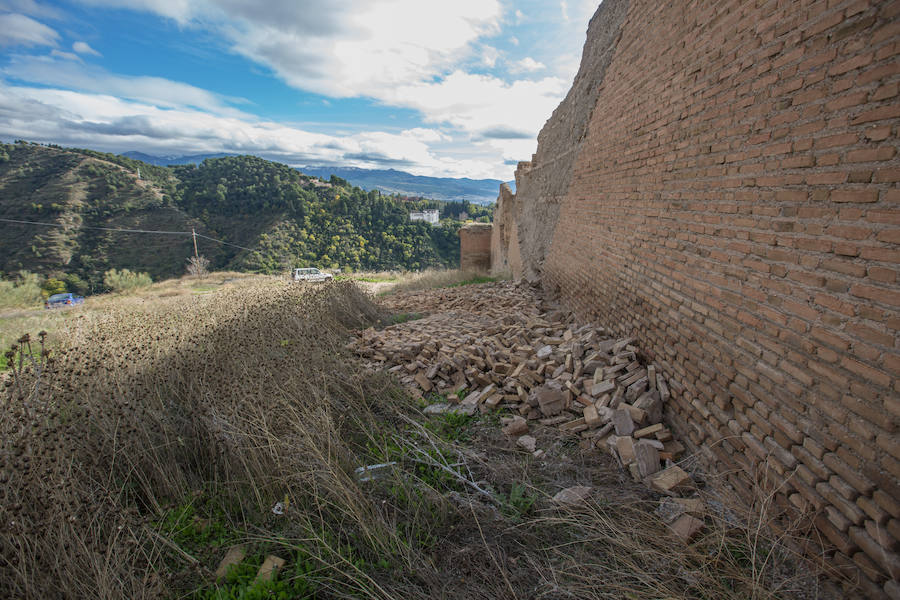 Cientos de ladrillos de lo que prodría ser el revestimiento de la muralla están amontonados junto a restos de basura