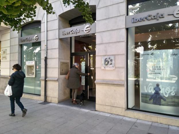 Una mujer entra en una entidad bancaria de Gran Vía. 