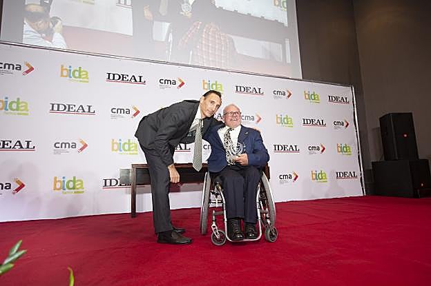 Manolo Robles se muestra feliz tras recibir el galardón de manos de Víctor Romero.