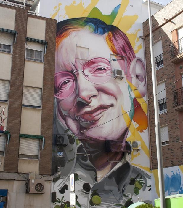 Personas observan desde abajo la obra hecha en la fachada de un edificio en Bailén. 