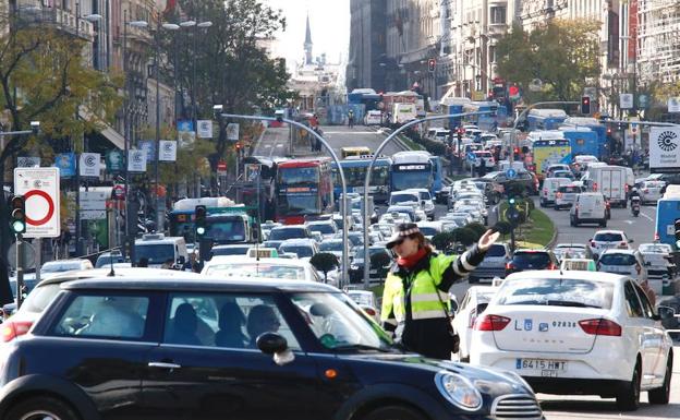 Una agente de Movilidad desvía un coche en el acceso a Madrid Central en la plaza de Cibeles esquina a la calle Alcalá, donde está instaladas las cámaras de control y los carteles que delimitan la zona.