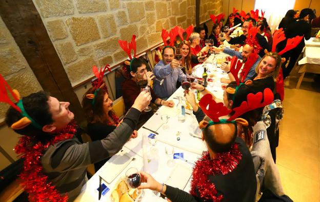 Brindis durante una cena de Navidad, con adornos de la época. :