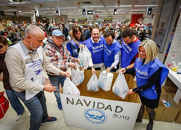 Voluntarios recogen alimentos en un centro comercial de Granada. 