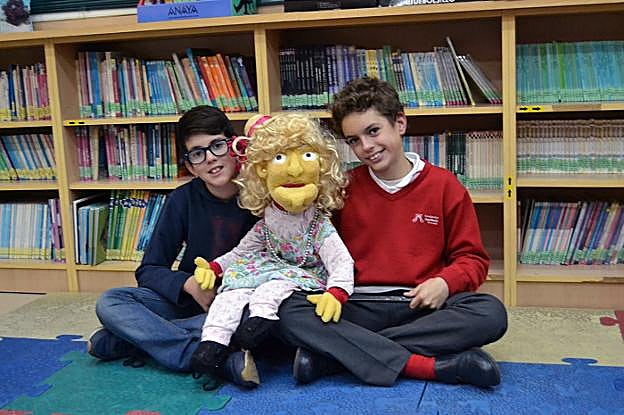Dos usuarios de la biblioteca de Híjar, con la marioneta.