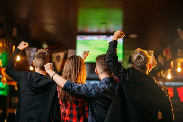 Foto de archivo de aficionados al fútbol viendo un partido en la televisión de un bar. 