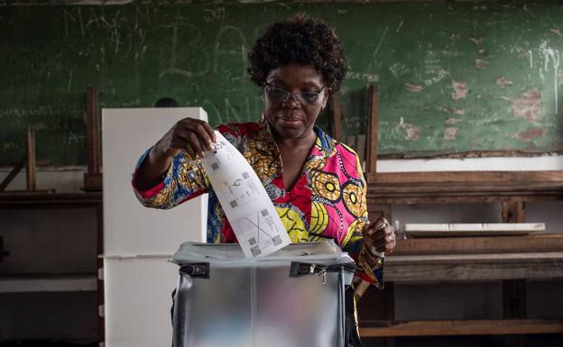Una votante deposita su papeleta en la urna en las elecciones de la R.D. Congo.