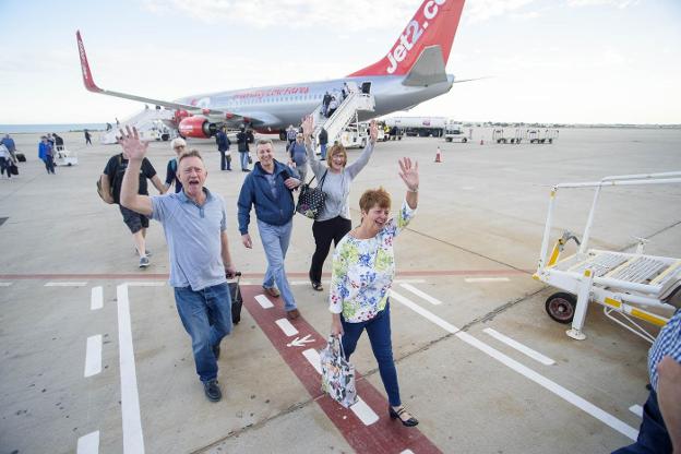 Un grupo de turistas desembarca de un avión en el Aeropuerto de Almería. A la derecha, Javier Aureliano García.