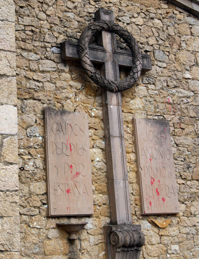 Placas falangistas al lado de una cruz en la fachada de la iglesia de Nava (Asturias).