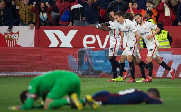 Los jugadores del Sevilla celebran el agónico empate ante la desolación de los futbolistas del Eibar.