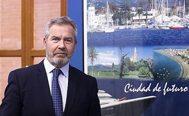 José García Fuentes posa junto a un póster en el que aparece el puerto de Motril. 