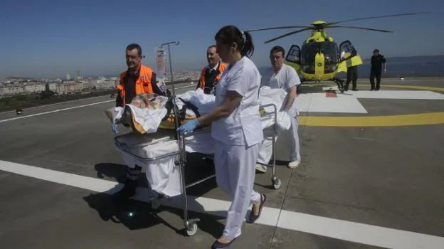 Despliegue de medios. Sanitarios reciben a un paciente trasladado en helicóptero hasta la azotea de un hospital gallego.