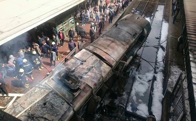 Los trabajadores de rescate supervisan los vagones incendiados.