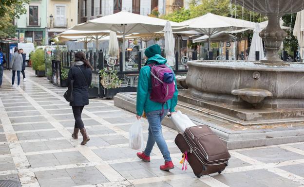 Un turista arrastra su maleta por Plaza Nueva
