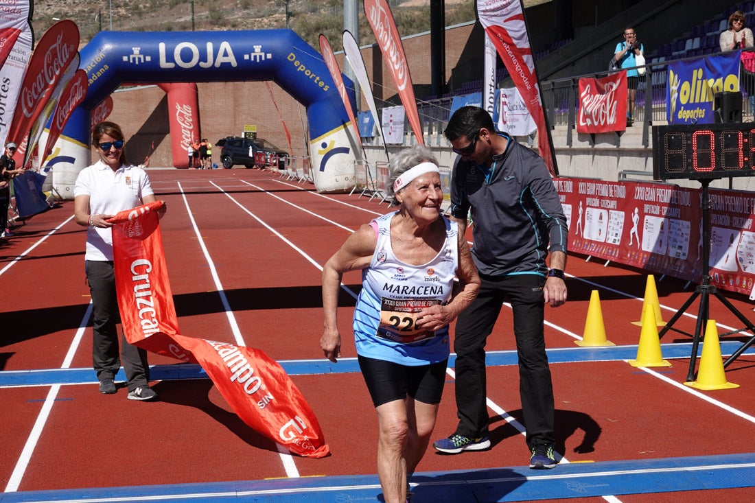 Manuel Santiago entra vistorioso a meta en la prueba de fondo de Loja. También lo hace victoriosa la más veterana de la cita. Y cientos de corredores desilan camino de la llegada al tartán.