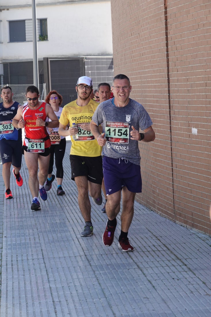 El reguero de atletas es amplio. Las piernas pesan en algunos momentos pero el objetivo de llegar a meta se mantiene. Si has participado en la carrera de fondo de Loja, prueba suerte a ver si te hemos retratado a lo largo del recorrido.