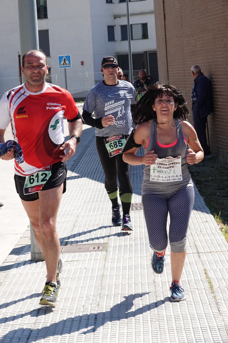 El reguero de atletas es amplio. Las piernas pesan en algunos momentos pero el objetivo de llegar a meta se mantiene. Si has participado en la carrera de fondo de Loja, prueba suerte a ver si te hemos retratado a lo largo del recorrido.